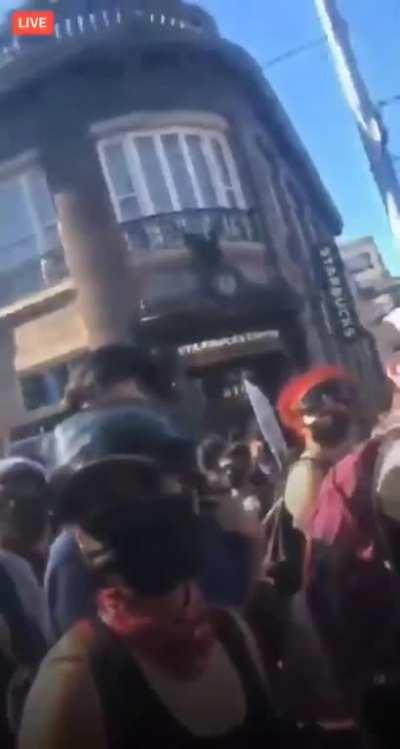 A crowd of people in Seattle yells at a man to stop filming before the riots started on Sunday