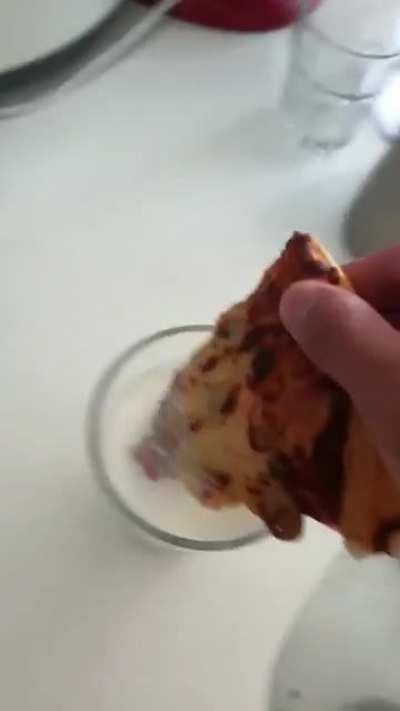 My friend dipping cold pizza in milk for breakfast