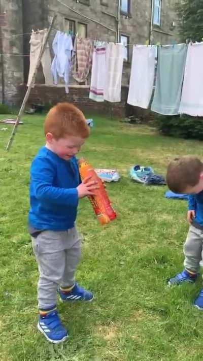 These two kids buckling over their juice.