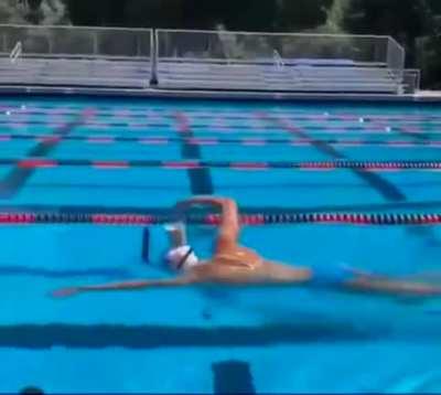 Competitive swimmer Katie Ledecky swims from one end of the pool to another with a cup of chocolate on her head without spilling a drop.