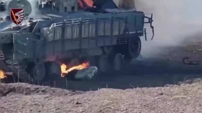 A crew member of a Russian BMP-3 tries to crawl out from under a burning vehicle. Donetsk region