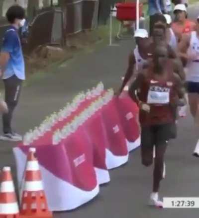 During the Olympic marathon, Amdouni knocks over an entire row of water before taking the last one.