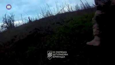 Two points of view of Ukrainian soldiers from the third assault brigade jumping for cover from two Russian grenades.