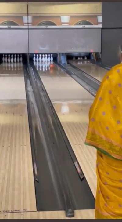 A video of an elderly lady in a saree bowling a strike.