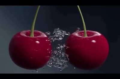 Two wet cherries colliding with each other.