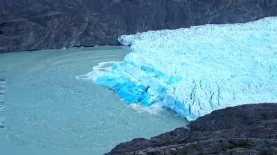 Iceberg flipping over revealing very old blue ice.