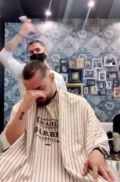 Barber cuts his own hair for cancer patient