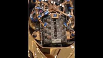 Jacob & Co's 'Bugatti Chiron Tourbillon' is a watch featuring a miniature version of the W16 Engine used in the Bugatti Chiron, which you can see. Cool, but why?