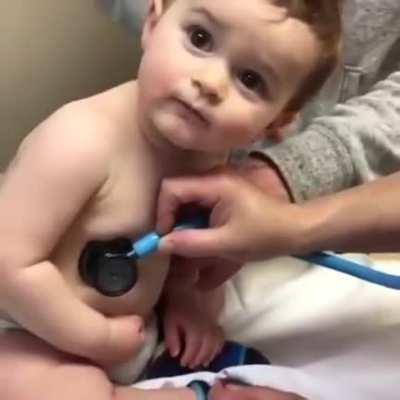 Cute baby resting it's head on doctor's hand.