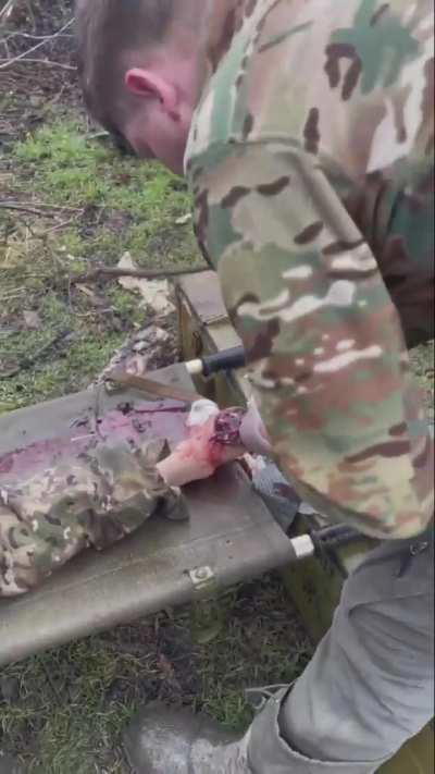 Russian medics providing aid to a soldier who looks to be in his 60's