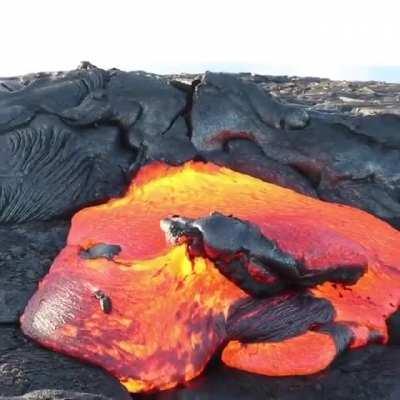 Lava breaking free from a congealing surface crust