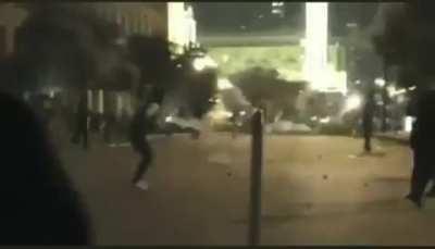 Lebanese potestor kicks back tear gas at police mid air.