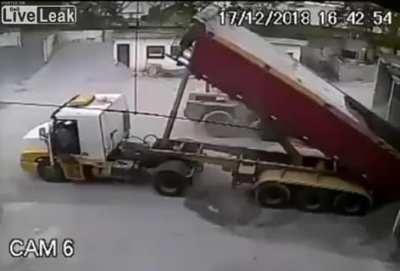 Hydraulic arm fails while dump truck is unloading its load.