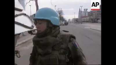 American paramedics and French peacekeepers protects civilians under their escort from Serb sniper fire in Sarajevo, Bosnia (March 11, 1995)