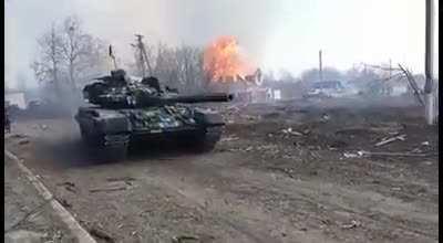 Ukrainian tank on the move with a massive explosion in the background. Location and date unknown.