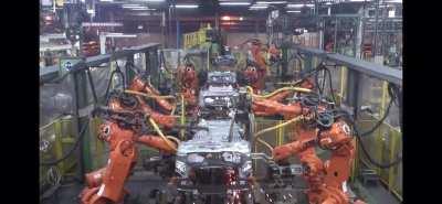 Spot welding robots on assembly line at car factory.